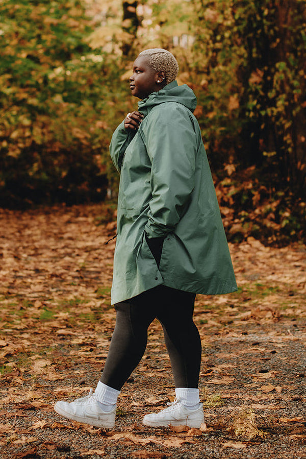 Person walking through a forest with autumn foliage