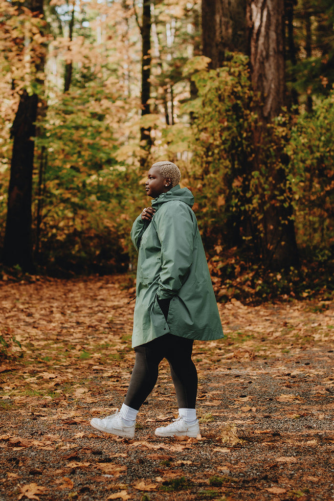 Person walking through a forest with autumn foliage